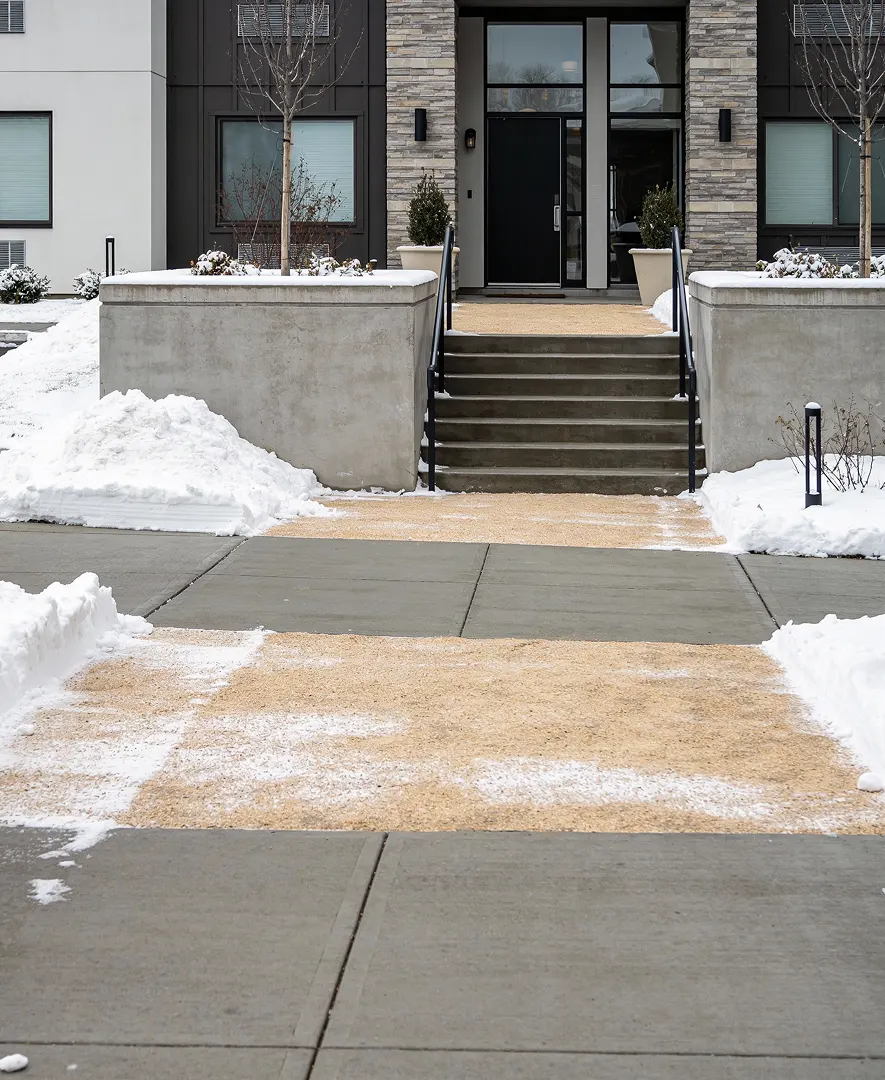 Cleared and de-iced walkway and stairs at a building entrance in winter