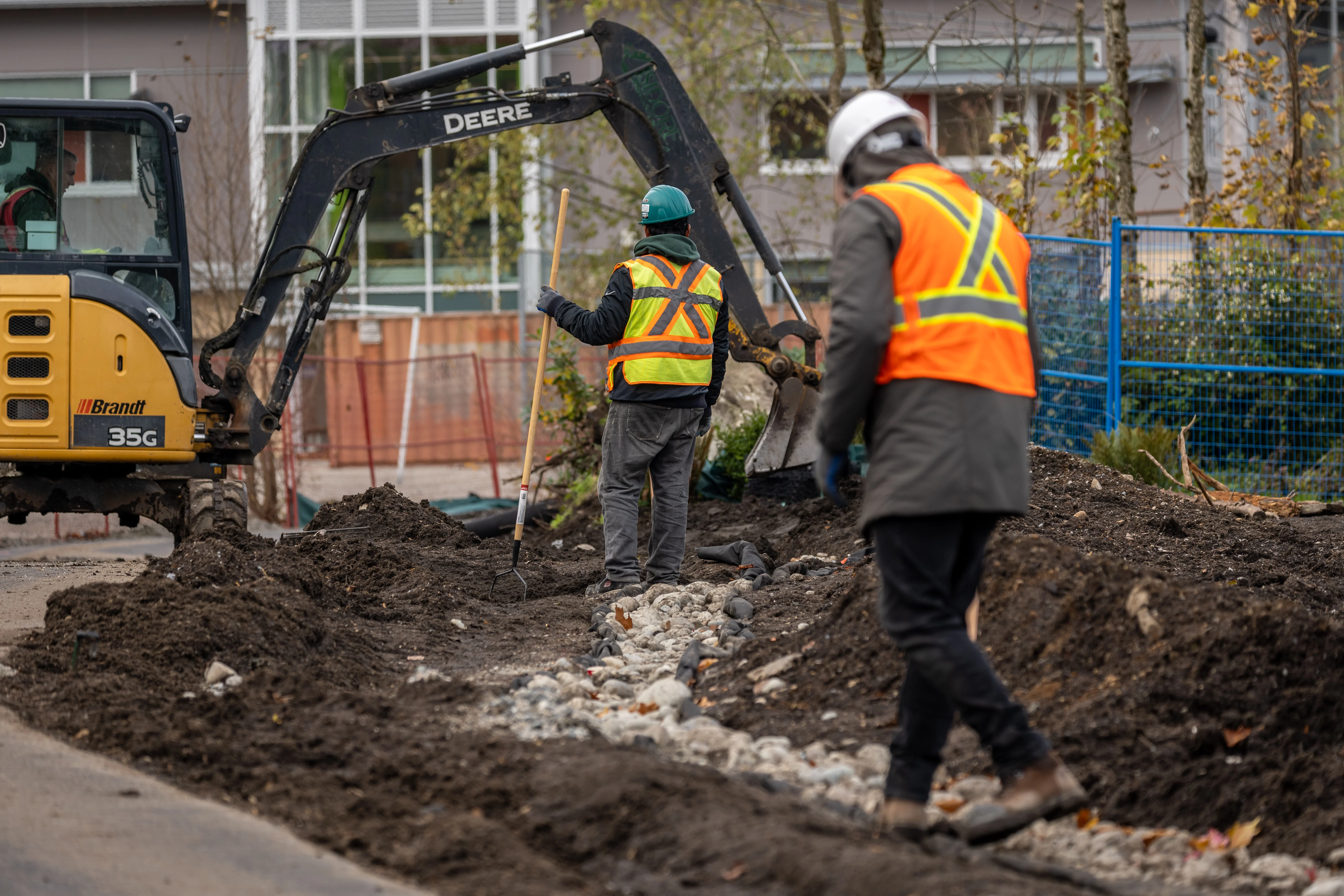 Crew working with a mini excavator on a landscape site